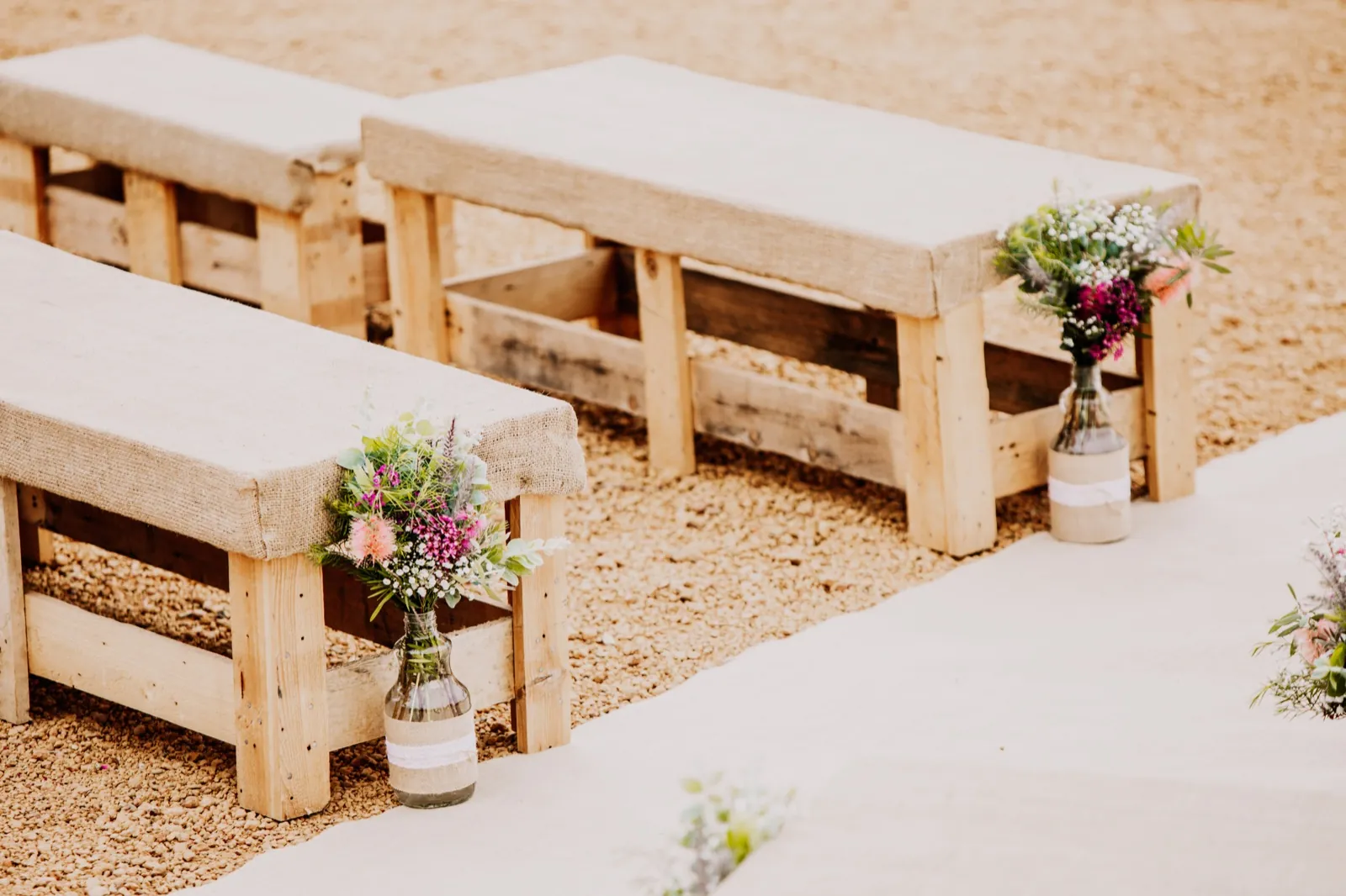 Timber ceremony benches with wildflowers