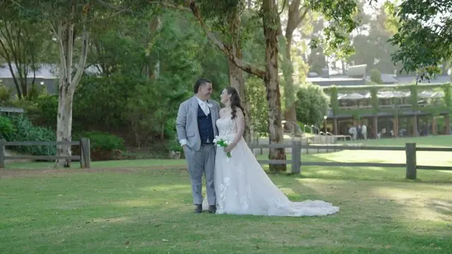 Wedding film still: couple on the lawn beneath gum trees at a Perth wedding