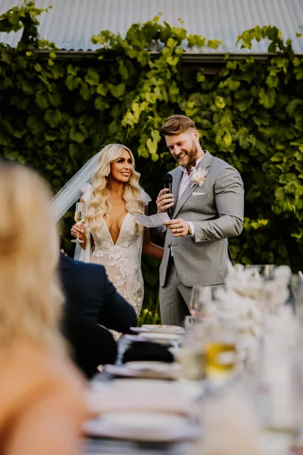 Guests raising a toast to the couple at the reception table