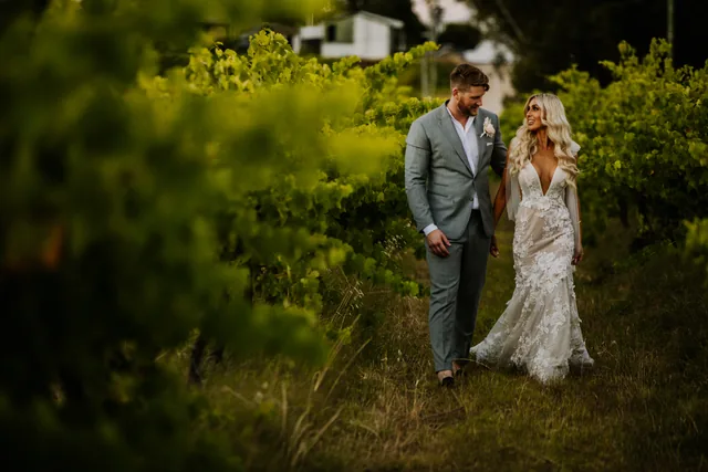 Bride and groom walking together through the vineyard