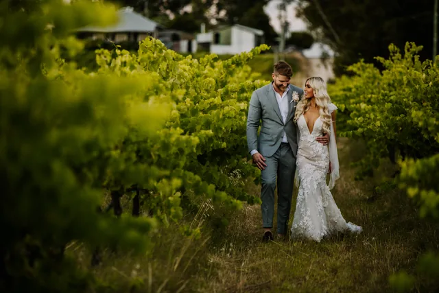 Bride and groom walking the vineyard at golden hour
