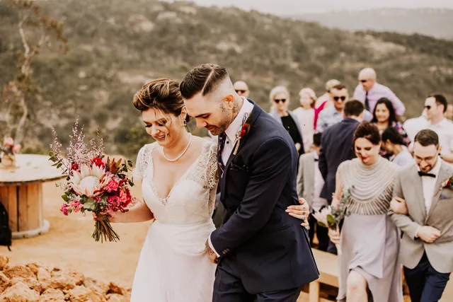Couple walking back down the aisle past their guests