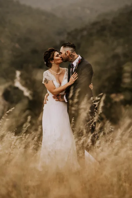 Couple embracing in the dry grass above the valley