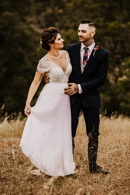 Bride and groom together in the dry hillside grass