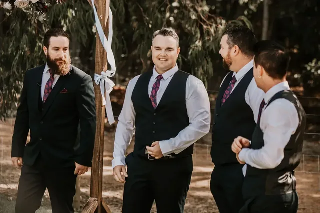 Groomsmen laughing together in the bush