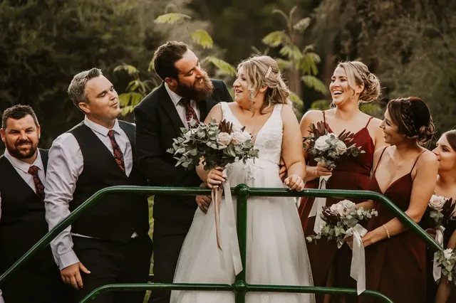 Bridal party laughing together on the bridge