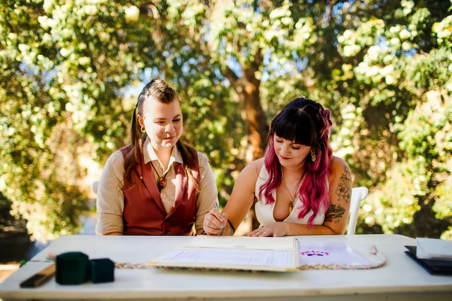 Signing the marriage register in the shade of the trees