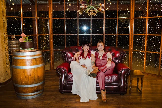 The two brides on a leather chesterfield under the fairy lights