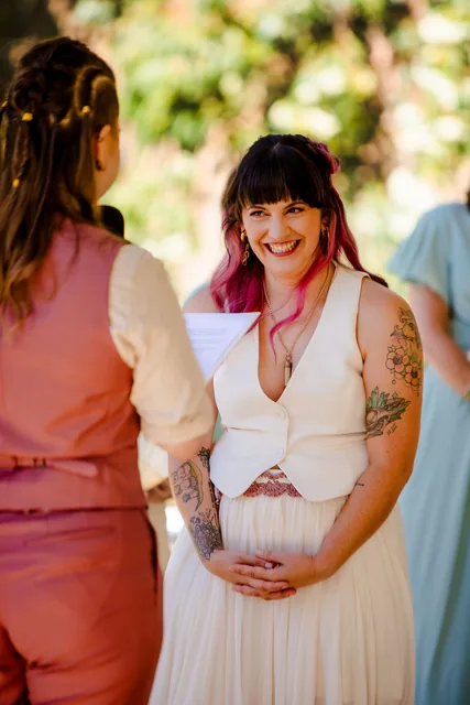 One of the brides laughing during the ceremony