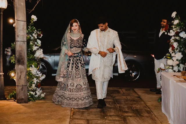 The couple in traditional dress arriving after dark