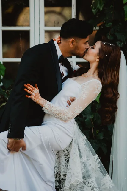 The groom dipping his bride against the ivy-covered Chateau wall