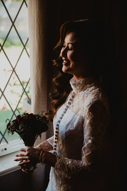 The bride at the leaded Chateau window, bouquet in hand
