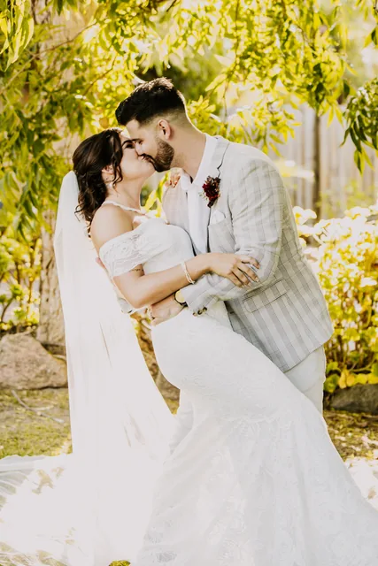 Groom dipping his bride beneath the trees at Henley Brook