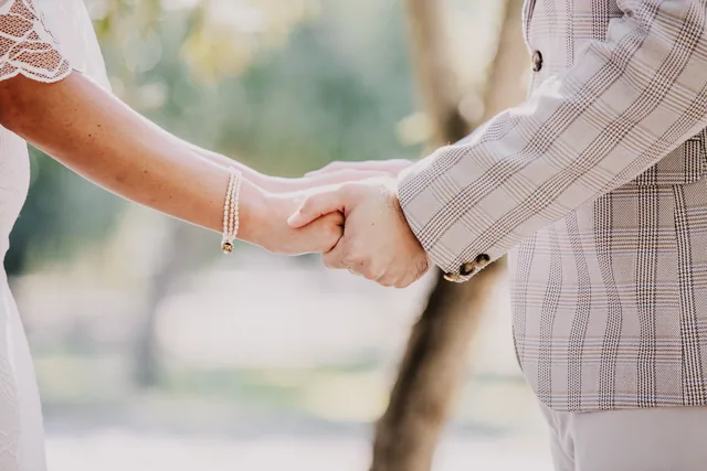 The couple holding hands during their ceremony