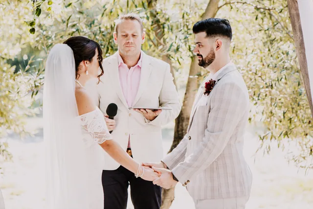 Bride and groom exchanging vows with their celebrant
