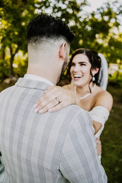 The bride's ring resting on her groom's shoulder