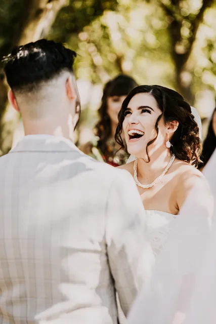 Bride laughing with her groom during the ceremony