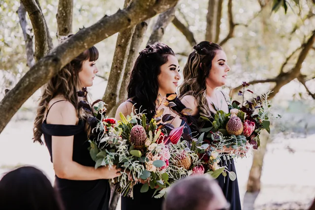 Bridesmaids in black holding native Australian bouquets